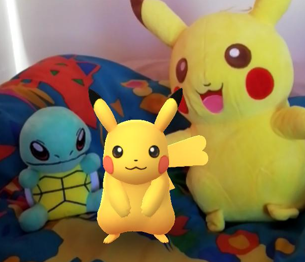 Here's one of my earliest catches, a Pikachu I got from some of my first field research, alongside some Pokemon I won in a claw machine. Yes, my duvet cover has dinosaurs on it.